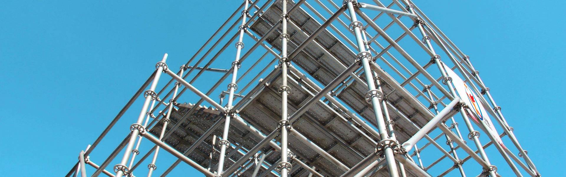 A erected ringlock scaffolding is displayed against the blue sky.