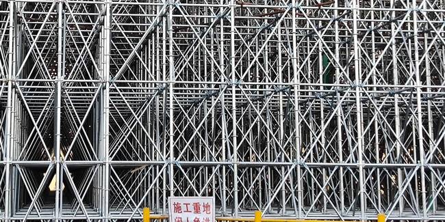A well-assembled modular scaffolding is erected firmly on the ground.
