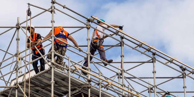 Several workers are working on the erected scaffold safely.